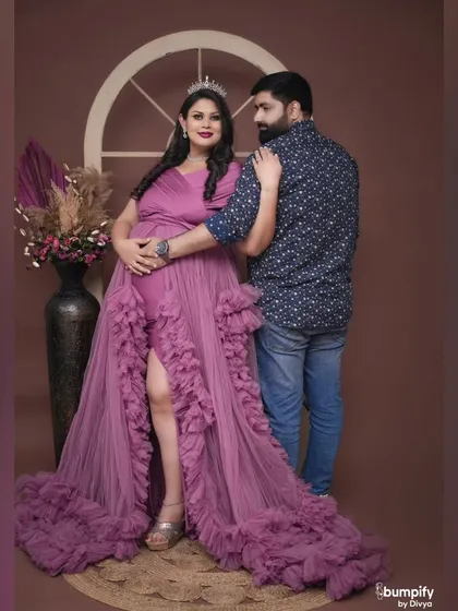 The couple shares a moment in this royal-themed shoot. The dad-to-be looks on lovingly as his partner shines in her purple gown.