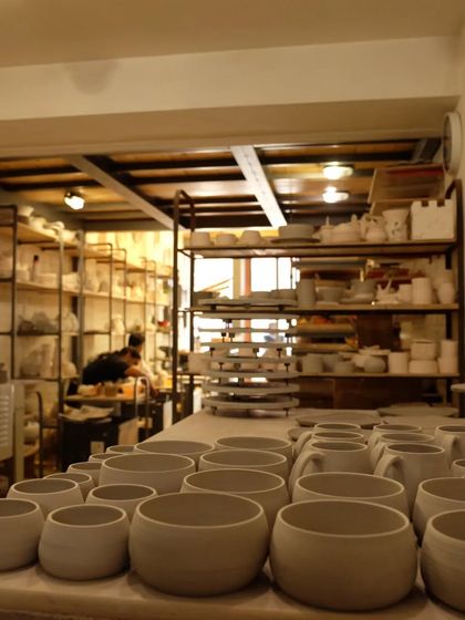 Awaiting their turn in the kiln. A collection of student-made bowls and mugs, known as greenware, lined up and ready for the next step.
