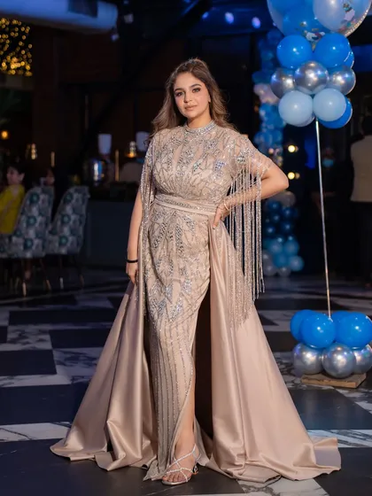 This is how you wear a statement gown. This beige gown with a fringed cape and satin trail is one of my signature pieces, perfect for making a grand entrance at any event.