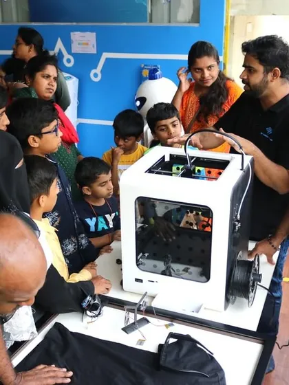 A crowd of curious visitors gathers to see a 3D printer in action at our RoboExpo. We showcase various future technologies to inspire kids and adults alike.