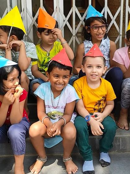 Happy faces in colorful party hats made during our summer camp. Crafting and wearing their own creations gives children a wonderful sense of accomplishment.