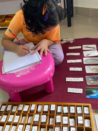 After building words with the movable alphabet, this child is now practicing writing them in her notebook. This natural progression from concrete to abstract builds confidence and a love for language.