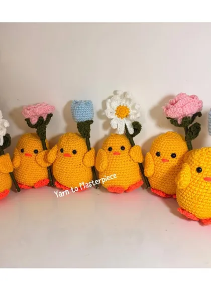 A whole flock of my crochet chicks, each holding a different flower like a daisy, rose, or tulip. They look so cute together!