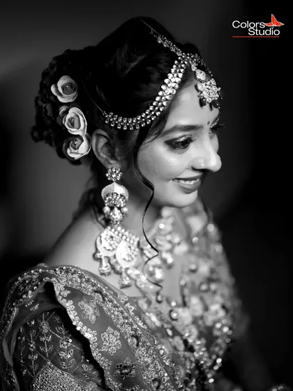 A classic black and white bridal portrait, focusing on her intricate jewelry and happy smile.