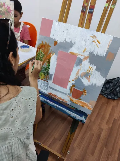 This series captures an adult student working on two different acrylic paintings, one a floral doorway and the other an abstract piece, showing the variety of styles we teach.