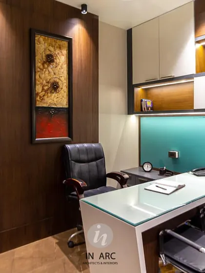 This is a director's cabin we designed for an educational institute in Nandigram. The space combines warm wood veneers with cool tones and strategic accent lighting to create an environment that is professional, focused, and sophisticated. Every element, from the glass-top desk to the built-in shelving, is chosen for function and style.