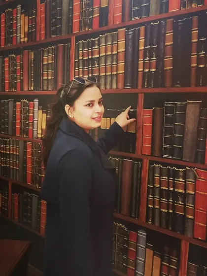 In a library, pointing to a book. This symbolizes my direct engagement with the source of law and knowledge, which is the foundation of my practice.