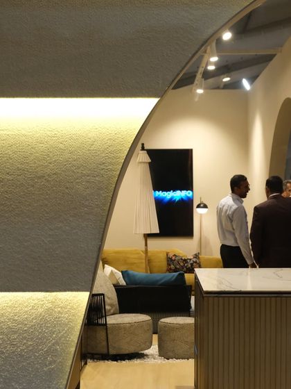 A view from within the booth, looking out through the arched openings. The design creates a feeling of being in a refined, gallery-like space, separate from the hustle of the main exhibition hall.