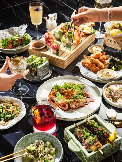 A great brunch is a full experience, and that's what I aimed to capture for Akina Mumbai. This lifestyle shot shows a vibrant spread of Japanese fusion dishes and drinks, with hands interacting to create a sense of a lively, shared meal.