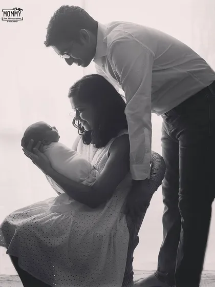 A timeless, backlit family silhouette. This black and white photo creates a beautiful, artistic feel, focusing on the shape and connection of the new family.