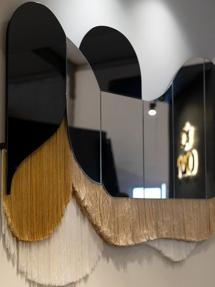 The 'Flapper Mirror' is a piece that blurs the line between furniture and artwork. Made with two tones of mirror and intricate threadwork, its organic shape and fringed detail add a soft, textural element to any wall.