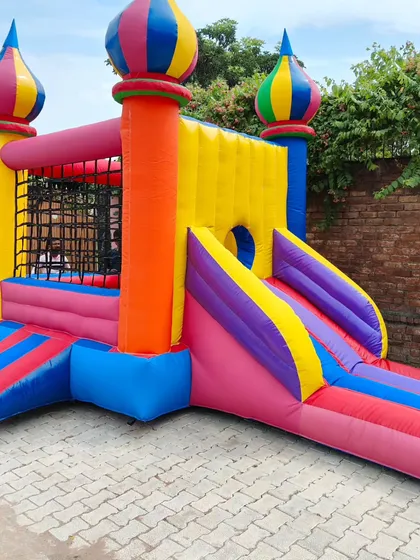 This colorful bouncy castle features unique onion-dome turrets and safety netting on the walls of the jumping area.