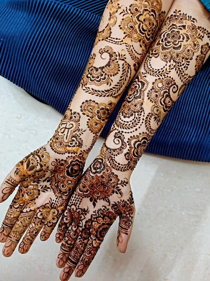 A beautiful engagement henna with paisley and floral motifs, and the initial 'R' hidden in the design.