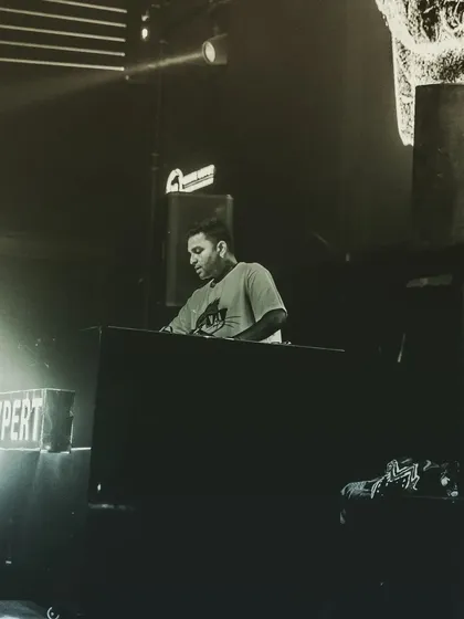 A black and white shot capturing the intensity of a live set. The focus is entirely on the music and the mix.
