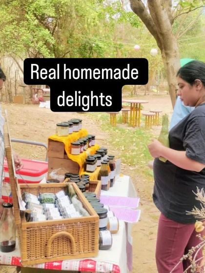 A home chef explaining her range of homemade preserves and coolers to an interested customer.
