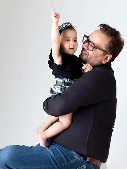 A father and daughter share a happy moment during a studio session. I aim to capture the unique bond between each parent and child in individual shots.