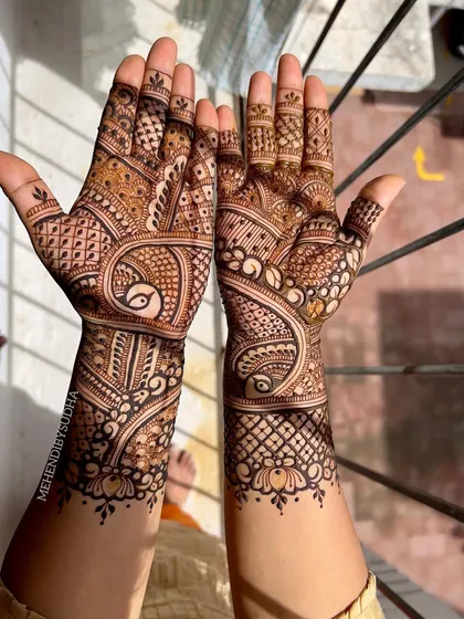 A lovely back-hand design featuring a peacock and paisley motif, with a delicate border at the wrist.