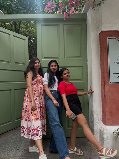 A group of friends posing against a beautiful green door in Pondicherry.