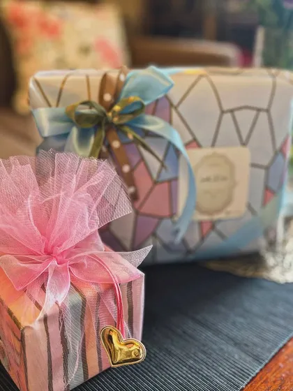 Gift wrapping for special occasions. This image shows two beautifully wrapped presents, one with a fluffy pink tulle bow and the other with a multi-layered satin ribbon, demonstrating my flair for elegant finishing touches.