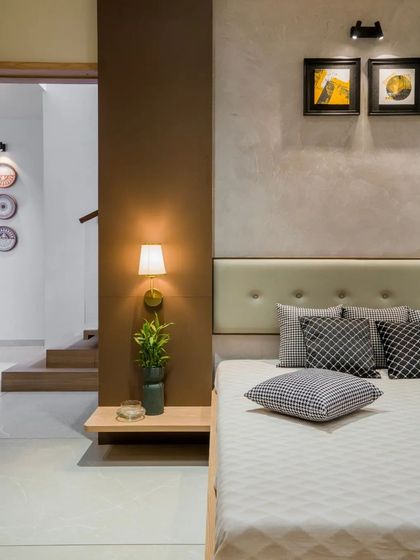 A bedroom with a simple, elegant design, where a floating bedside table and warm lighting create a calm and uncluttered space.