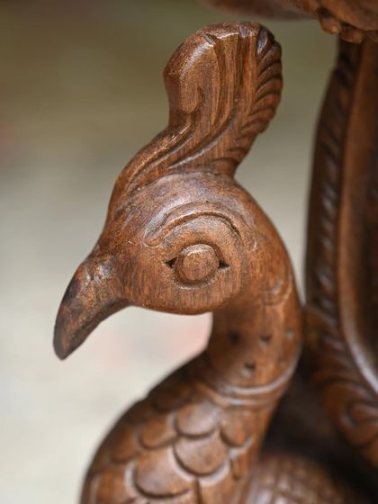 A close-up of the peacock's head from the 24-inch Murugan statue, showcasing the detailed carving.