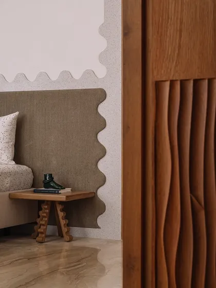 The guest bedroom at Rehethaan is a cozy oasis. A terracotta-coloured arched niche provides a home for books, while a custom terrazzo architrave with a wavy profile adds a dash of whimsy to the room.