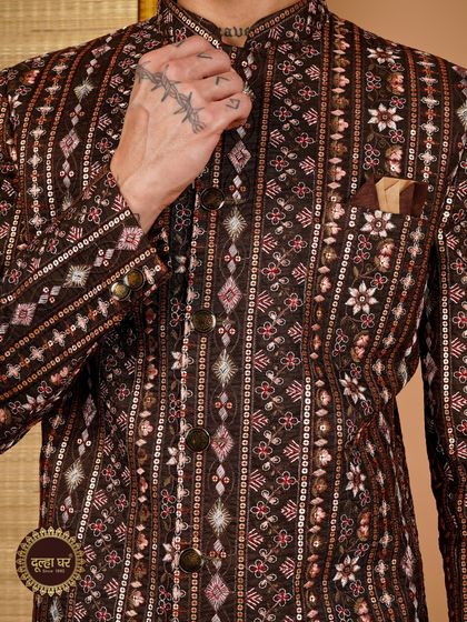A groom's royal look starts here. A close-up of a brown sherwani, showcasing the dense, multi-patterned embroidery and sequin work.