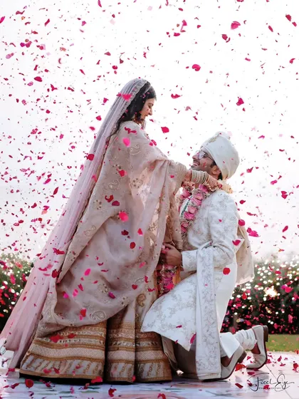 The beautiful varmala ceremony, where the groom kneels amidst a shower of petals. It's these emotional, unscripted moments that we love to capture.