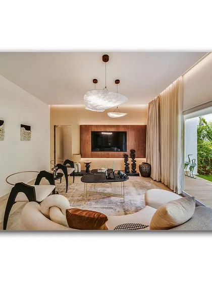 A contemporary living room with a sculptural sofa and unique art pieces. The space opens up to a lush garden, creating a seamless indoor-outdoor connection that is perfect for modern living.