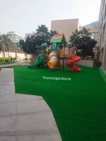 I create safe and fun play areas for children. This installation features my shock-absorbent artificial turf around a playground set, providing a soft landing surface that stays green all year.