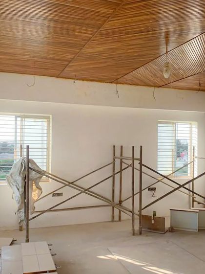 Another angle of the room under construction, showing the beautiful grain and pattern of the diagonal teak wood ceiling we designed.