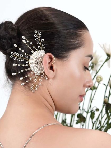 A model showcasing our fan-like pearl and crystal earcuff, styled with an elegant updo to let the piece shine.