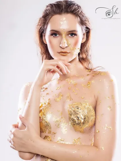 A high-fashion portrait of a model with artistic gold leaf makeup and a confident pose. This is an example of our work for model portfolios and creative editorials that require a unique and bold aesthetic.