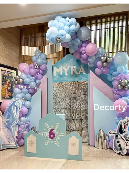 The Frozen-themed backdrop for Myra's party, featuring a life-sized Elsa cutout and a friendly Olaf.
