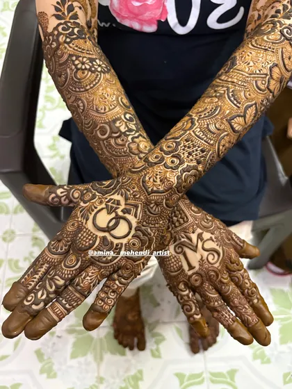This design features the couple's initials 'M' and 'S' along with interlocking rings, a popular choice for engagement and bridal mehendi.