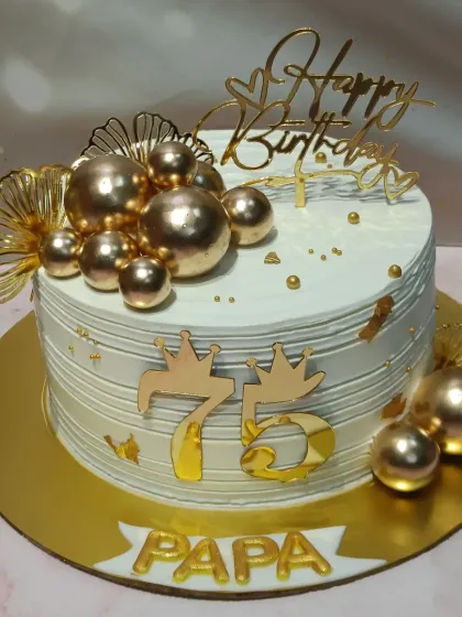 Celebrating 75 years with a touch of gold. This cake is adorned with a cascade of golden spheres, fan details, and a prominent "75" topper, making it a truly grand centerpiece for a papa's special day.