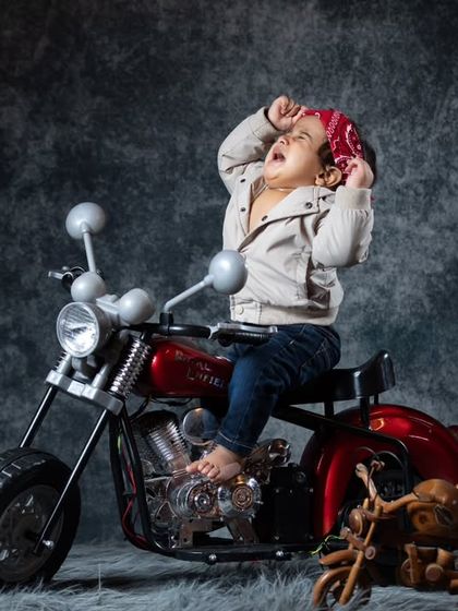 A dramatic pose from our little biker, showing off his wild side. I love capturing these expressive moments that showcase the baby's personality.
