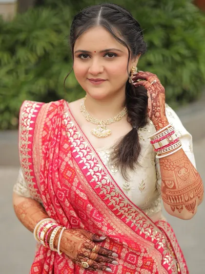 A lovely portrait of the bride. Her makeup is minimal and fresh, letting her happy expression and the traditional details of her outfit take center stage.