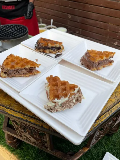 An assortment of our popular waffles presented on an ornate table, ready for guests to enjoy. This shows how we integrate our food stations with the event's decor.