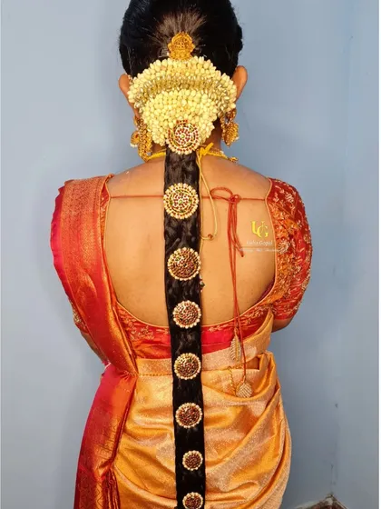 A detailed look at a traditional South Indian bridal braid for Geetha. This hairstyle features a classic braid adorned with fresh jasmine flowers (mallipoo) and temple-style jada billai, perfect for a muhurtham ceremony.