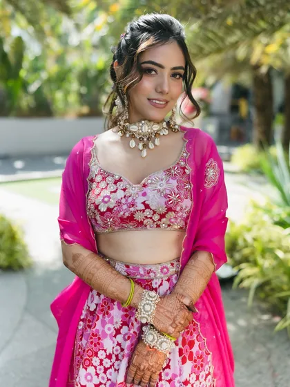 A playful and romantic updo with soft tendrils and braids, perfect for a fun Haldi or Mehendi ceremony.