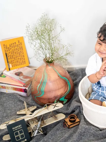 This little explorer is surrounded by props that hint at future adventures: books, a passport, and a toy airplane. It's a creative and personalized first birthday theme.
