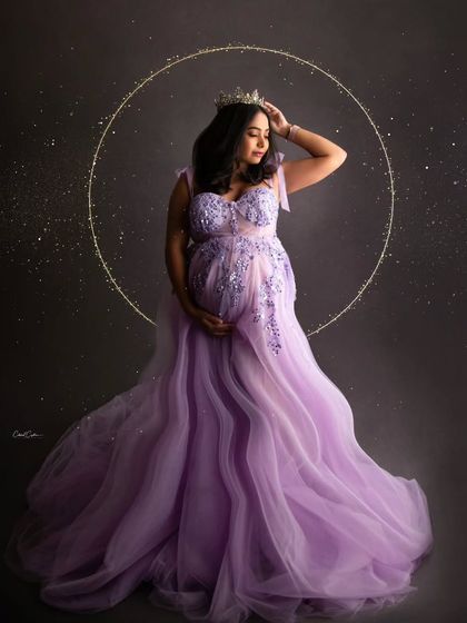 A truly regal portrait. This mom-to-be wears a crown and is framed by a golden halo, looking absolutely majestic in her lavender gown.