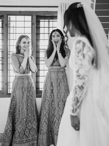 The "first look" moment, capturing the bridesmaids' surprised and delighted reactions to seeing the bride in her gown.