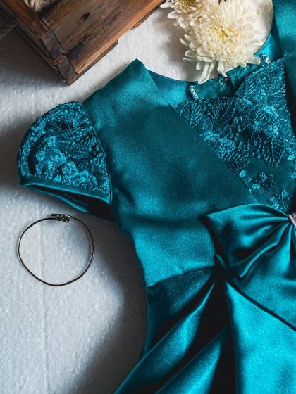 The deep peacock blue of this satin dress is simply captivating. I added sequined lace to the puff sleeves and bodice for a touch of sparkle, creating a gown that's both rich and elegant.
