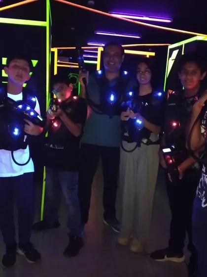 A family poses together in the laser tag arena, showing that it's a great bonding activity.