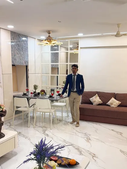 Here I am in a recently completed living and dining area. You can see how the foldable dining table integrates seamlessly with the overall design, complemented by a large mirror wall that enhances the sense of space.