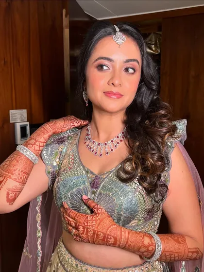 A candid shot of Neha, her makeup looking radiant and her pastel lehenga shining.