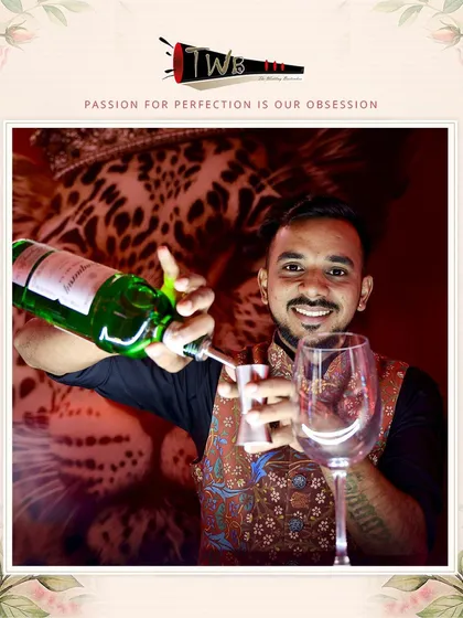 A smiling bartender pours champagne, ready to serve guests at a vibrant Sangeet celebration.