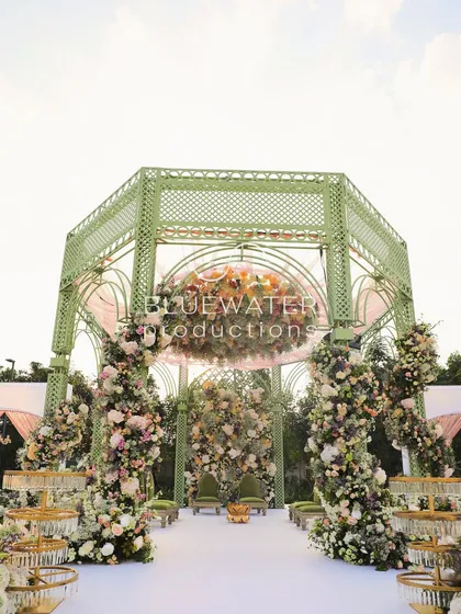 Inspired by French garden gazebos, we designed this soft green lattice mandap for an elegant outdoor wedding. It was built to feel as if it had always been part of the landscape, blending structure with nature.